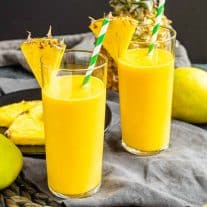 two Mango Pineapple Smoothie with pineapple wedges