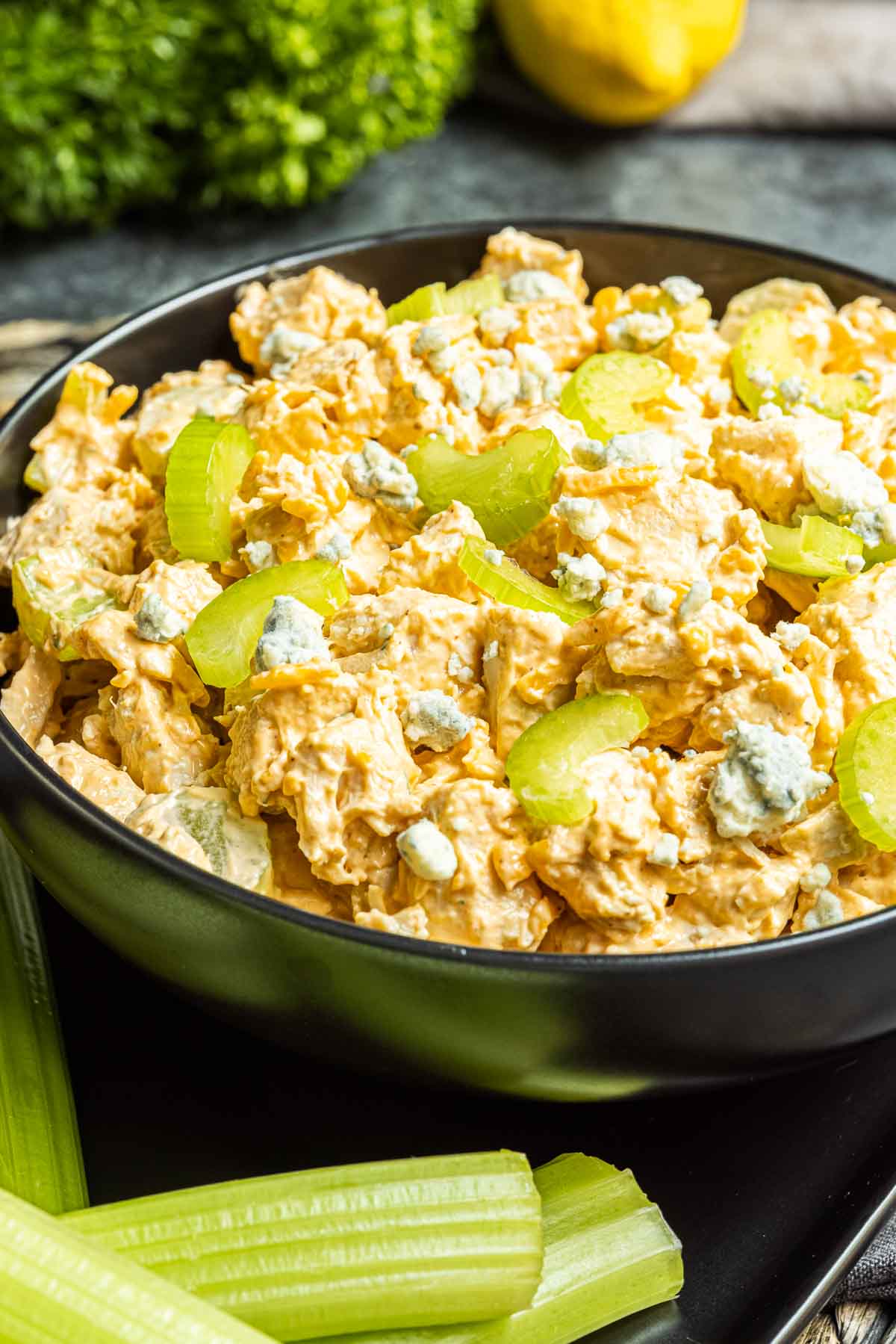 Buffalo Chicken Salad in a black bowl topped with celery