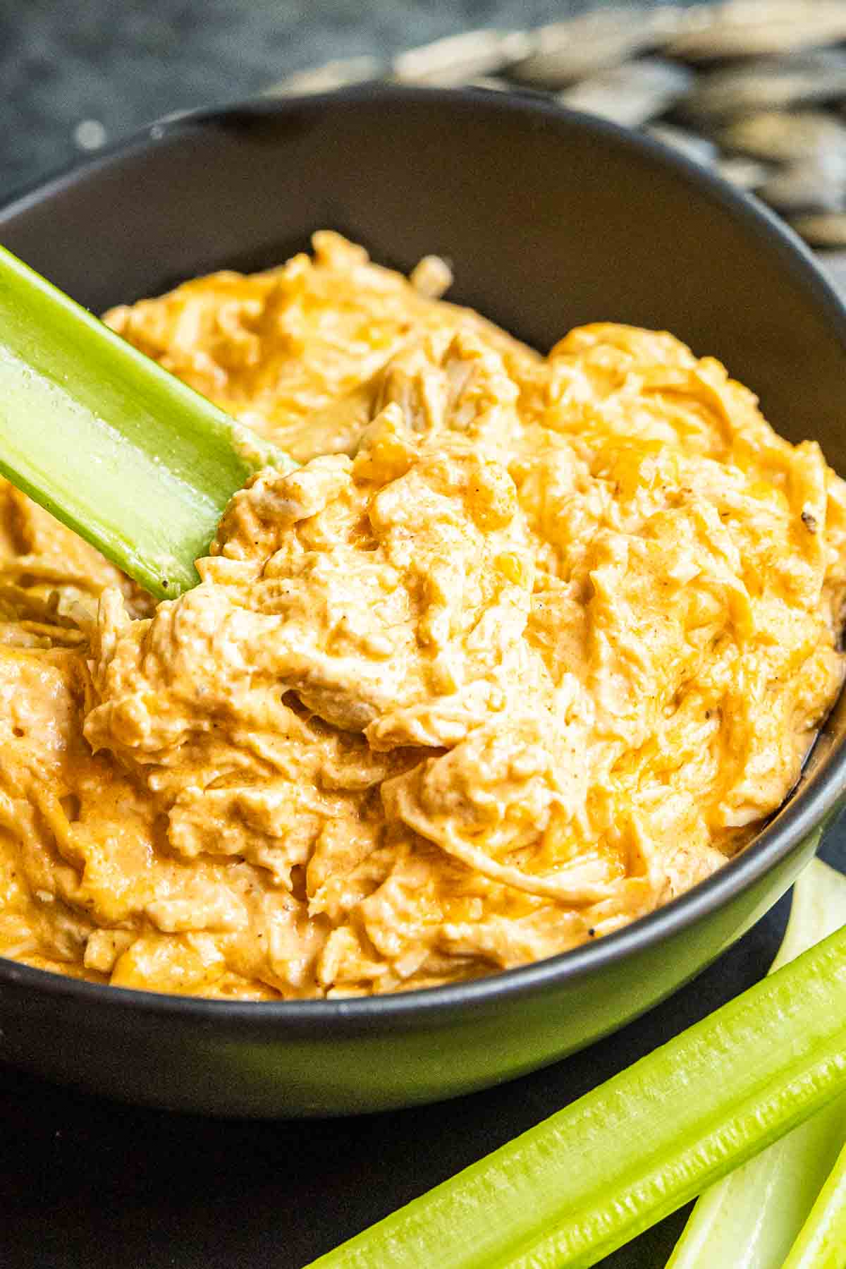 bowl of Instant Pot Buffalo Chicken Dip with celery stick in it