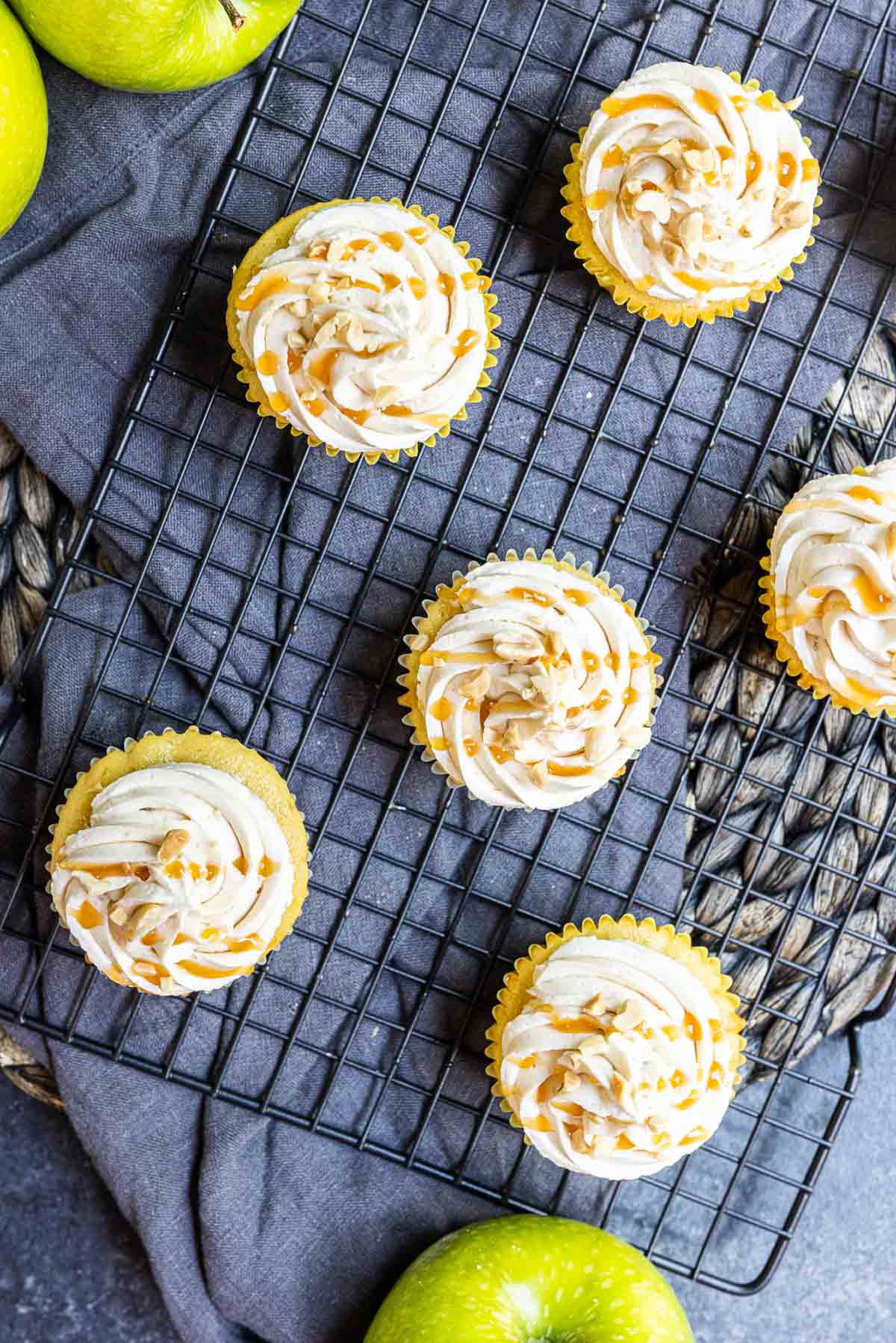 Top down shot of frosted caramel apple cupcakes with a drizzle of caramel on top