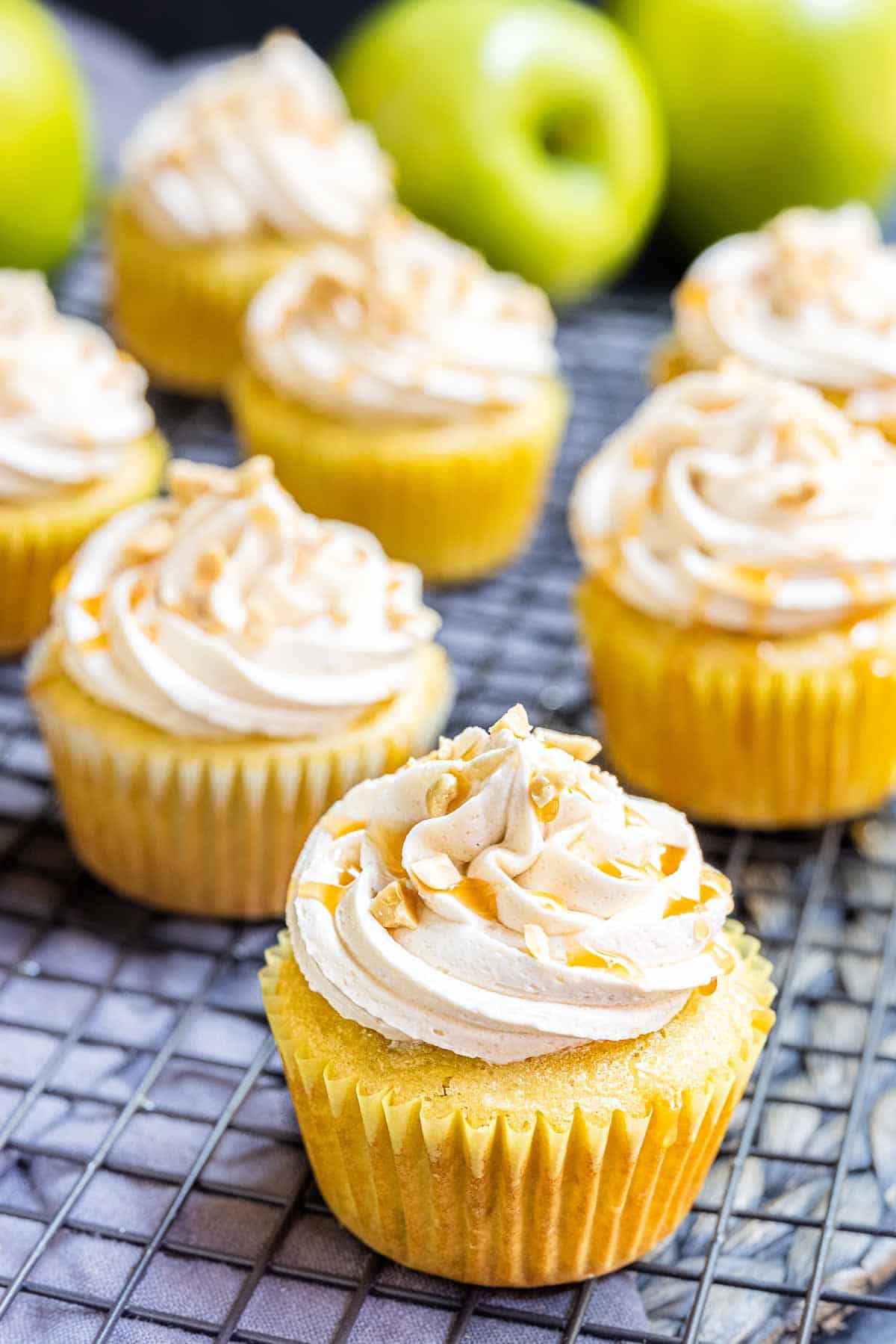 Caramel apple cupcakes with a drizzle of caramel sauce on top.