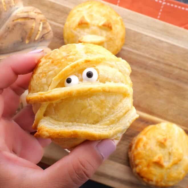 holding Halloween Baked Cheese mummy with eyes