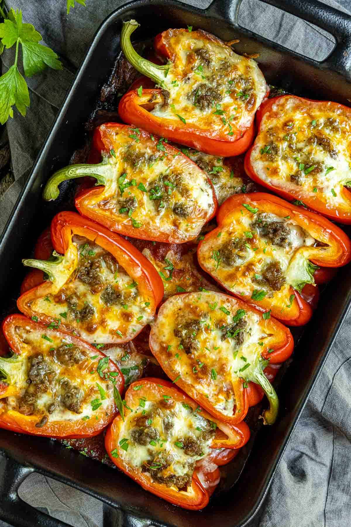 Lasagna Stuffed Peppers in black dish garnished with chopped parsley