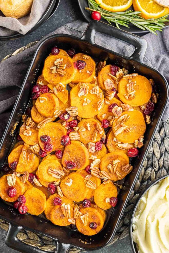 holiday Cranberry Sweet Potato Casserole in black casserole dish with chopped pecans