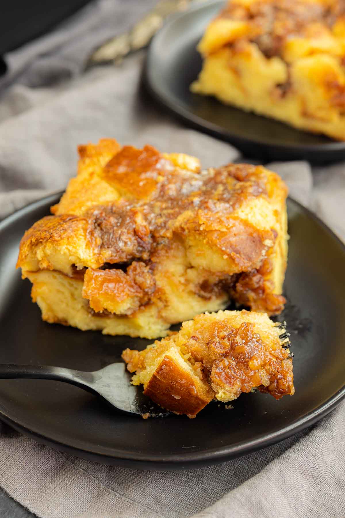Pecan Pie Bread Pudding on a fork on black plate