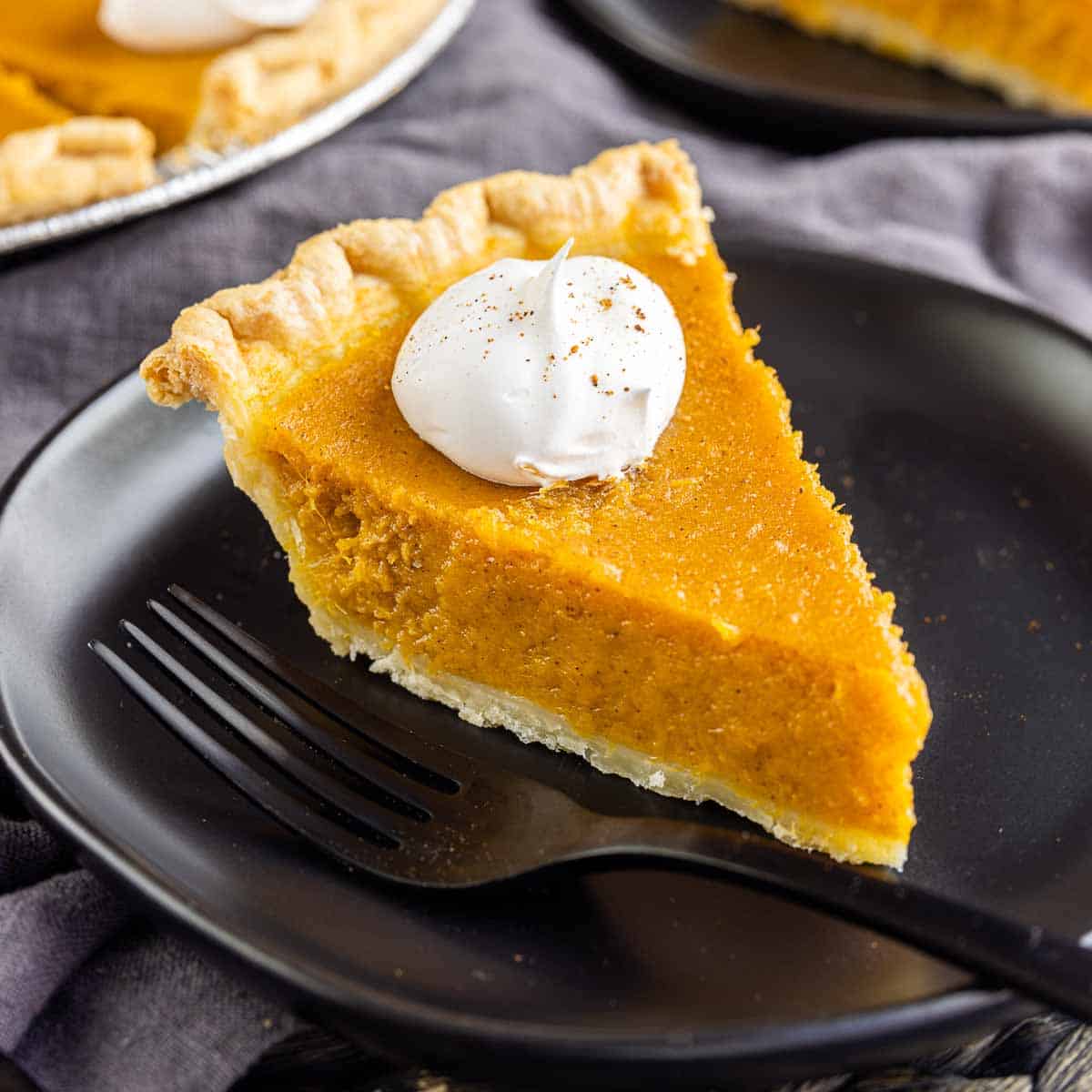 sweet potato pie on a black plate with fork