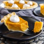 sweet potato pie on a black plate with fork