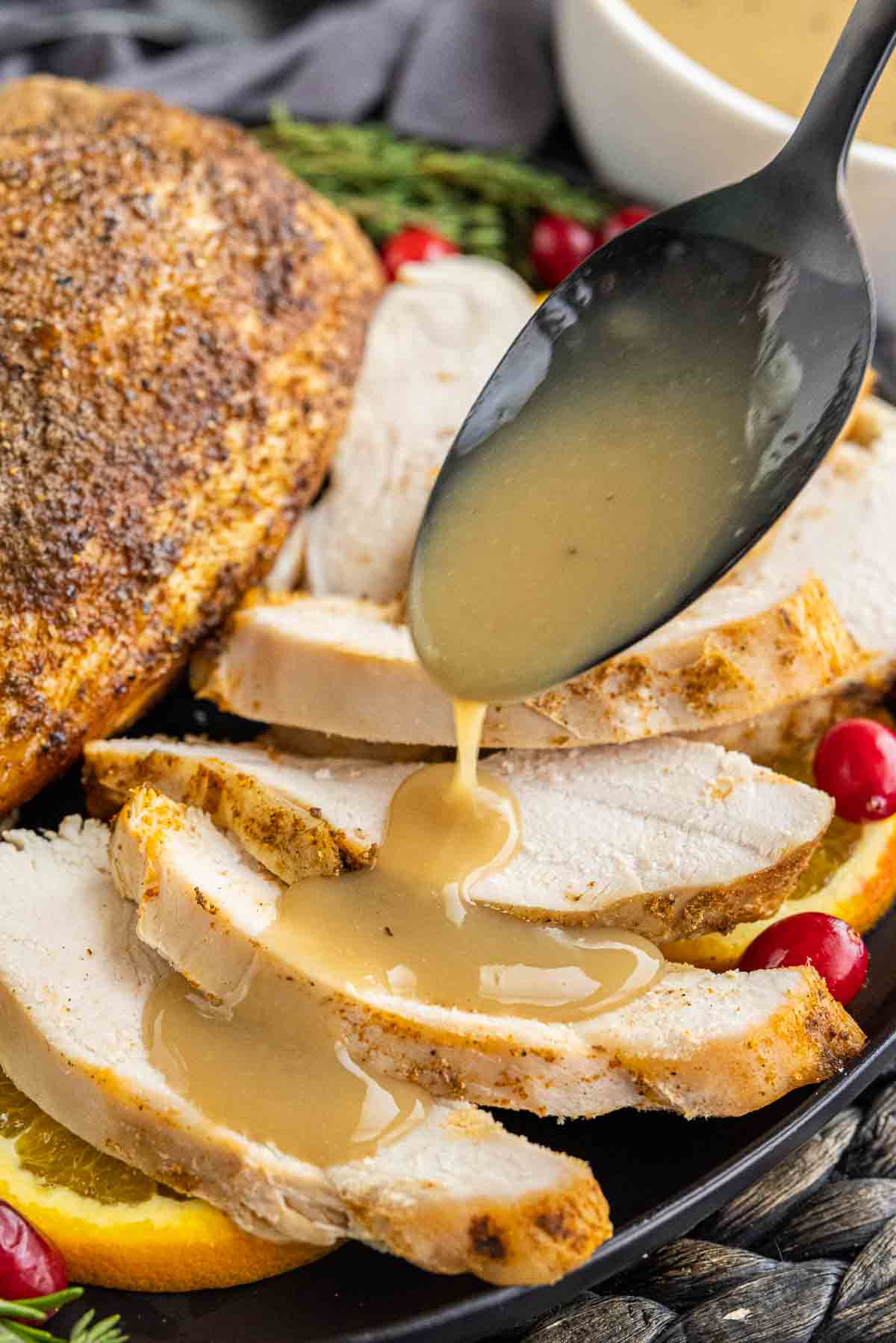 Turkey Gravy on a spoon drizzled over turkey breast