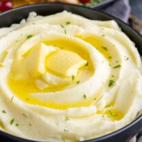 Not Your Mom’s Mashed Potatoes in a bowl with butter and garnished with parsley