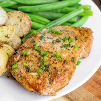 Baked Ranch Pork Chops on a white plate garnished with green onions