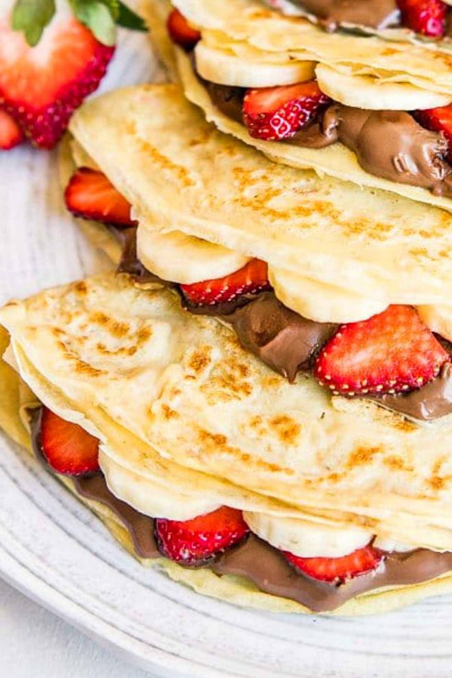 Close up of Nutella crepes in a line with bananas and strawberries
