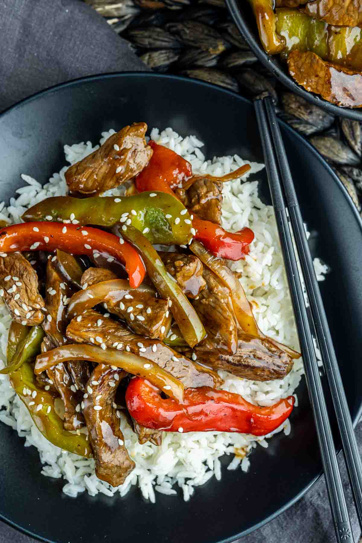 Easy Pepper Steak on a black plate with chopsticks