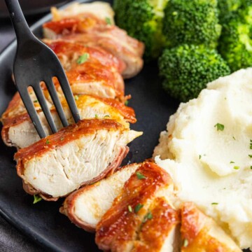 piece of Prosciutto Wrapped Chicken on a black fork