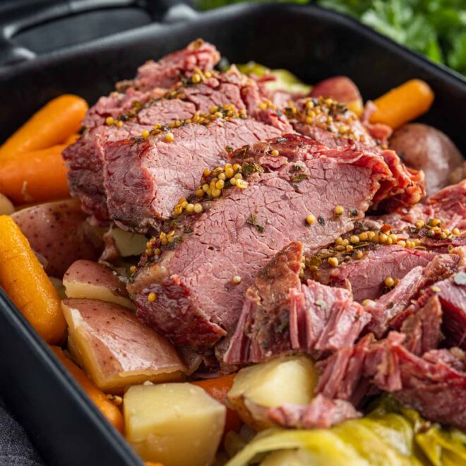 black platter with sliced Instant Pot Corned Beef with cabbage and potatoes