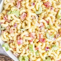 white bowl filled with Classic Macaroni Salad and wooden spoon