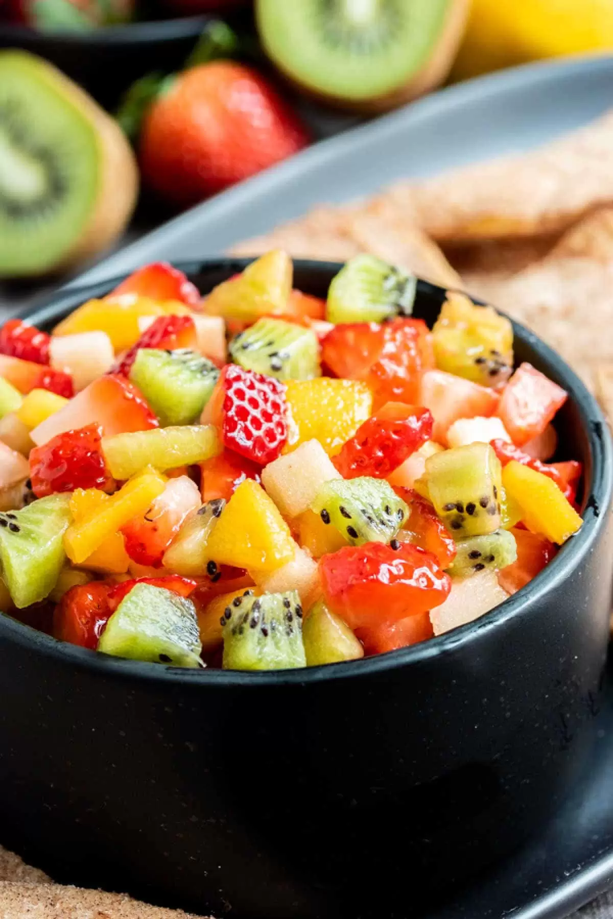 black bowl filled with colorful fruit salsa