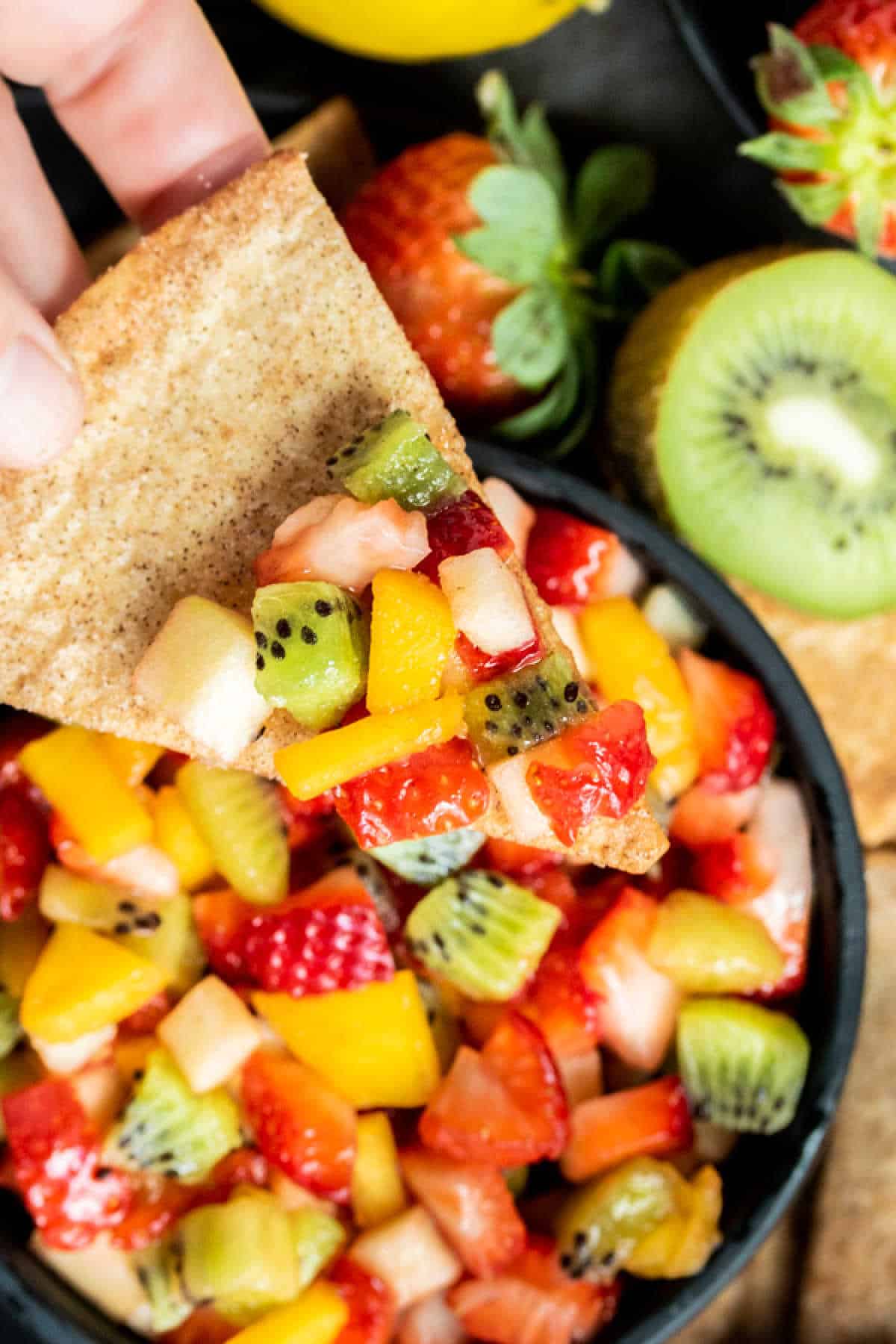 Scoop of fruit salsa on a baked cinnamon chip