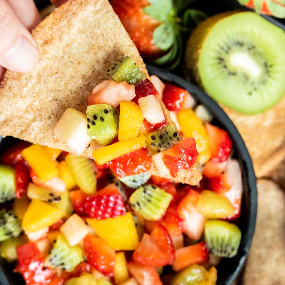 Scoop of fruit salsa on a baked cinnamon chip