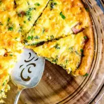Low Carb Ham and Cheese Crustless Quiche in a clear dish with a server