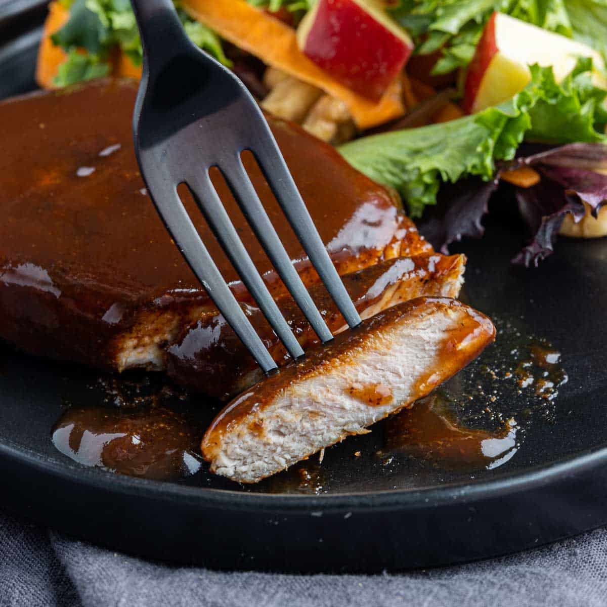 cut Air Fryer BBQ Pork Chops on a black plate