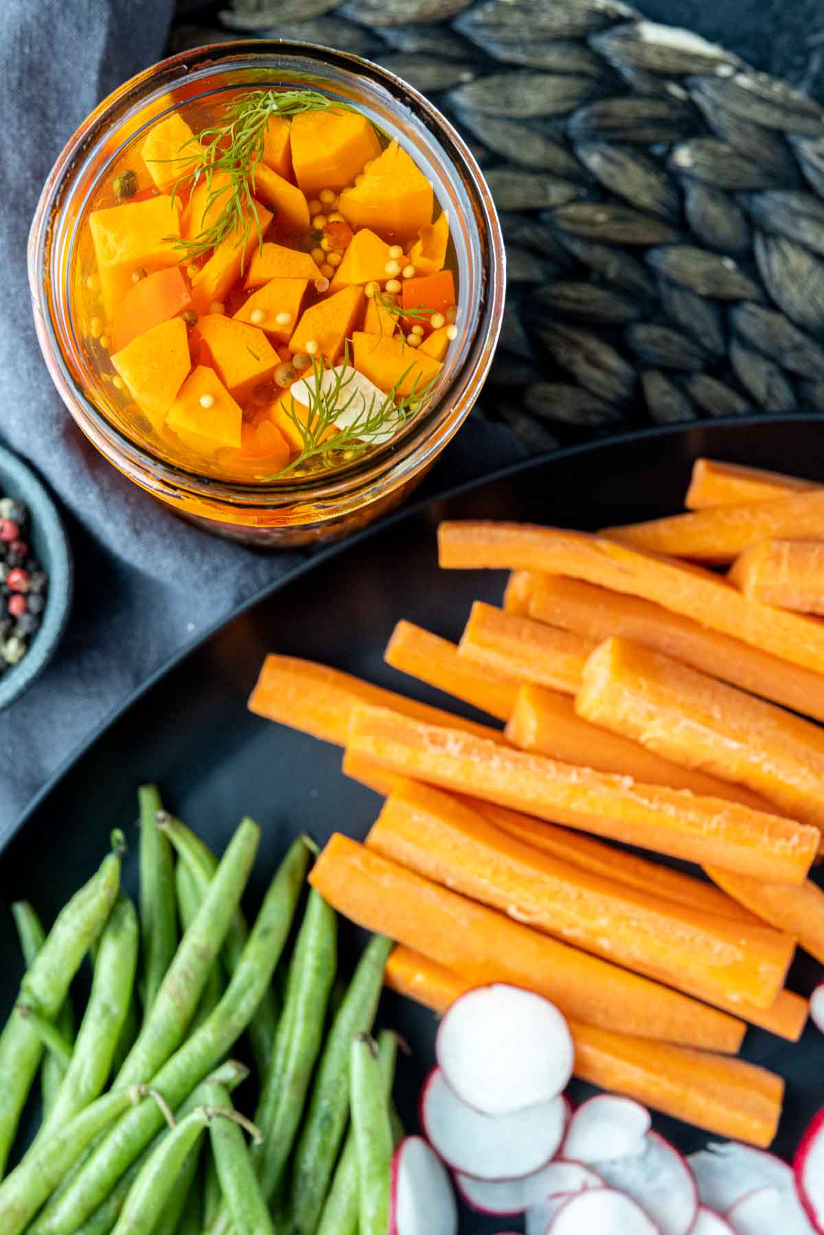 jar of Pickled Carrots with carrot sticks on a plate