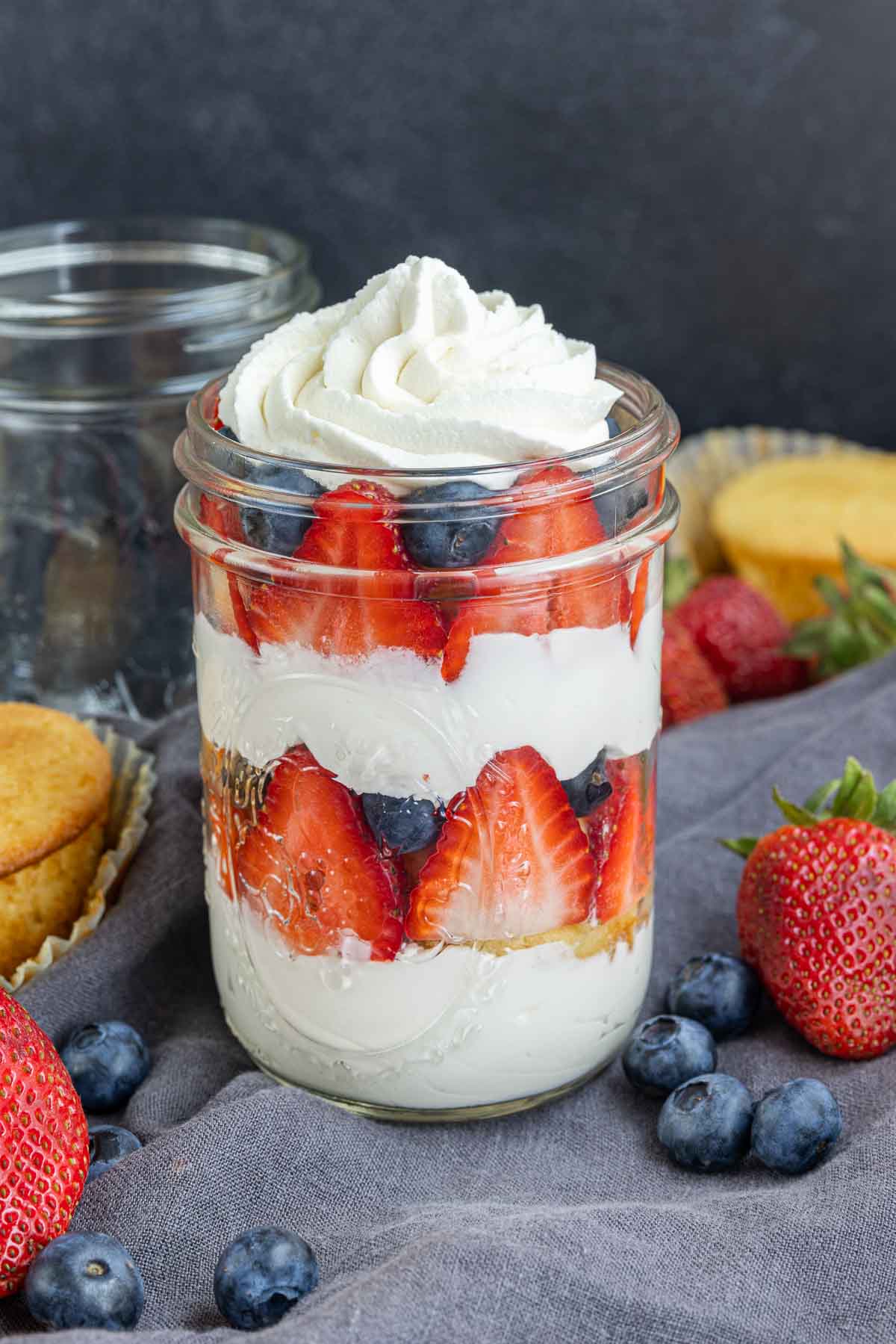 cupcakes in a jar with fresh fruit and whipped cream. Topped with 4th of July stars