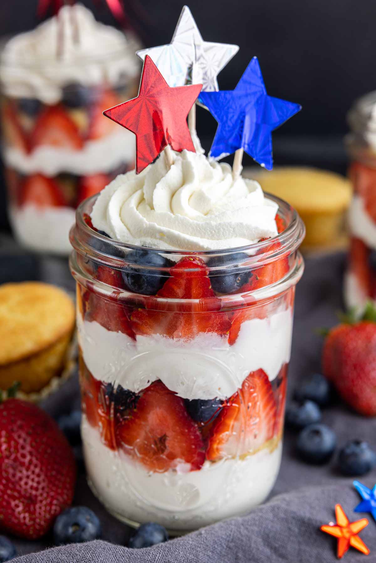 cupcakes in a jar with fresh fruit and whipped cream. Topped with 4th of July stars