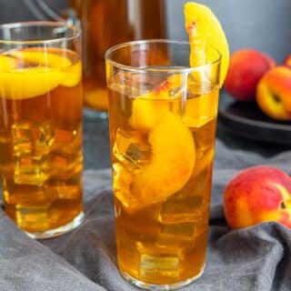 glasses with Peach Iced Tea garnished with a peach slice