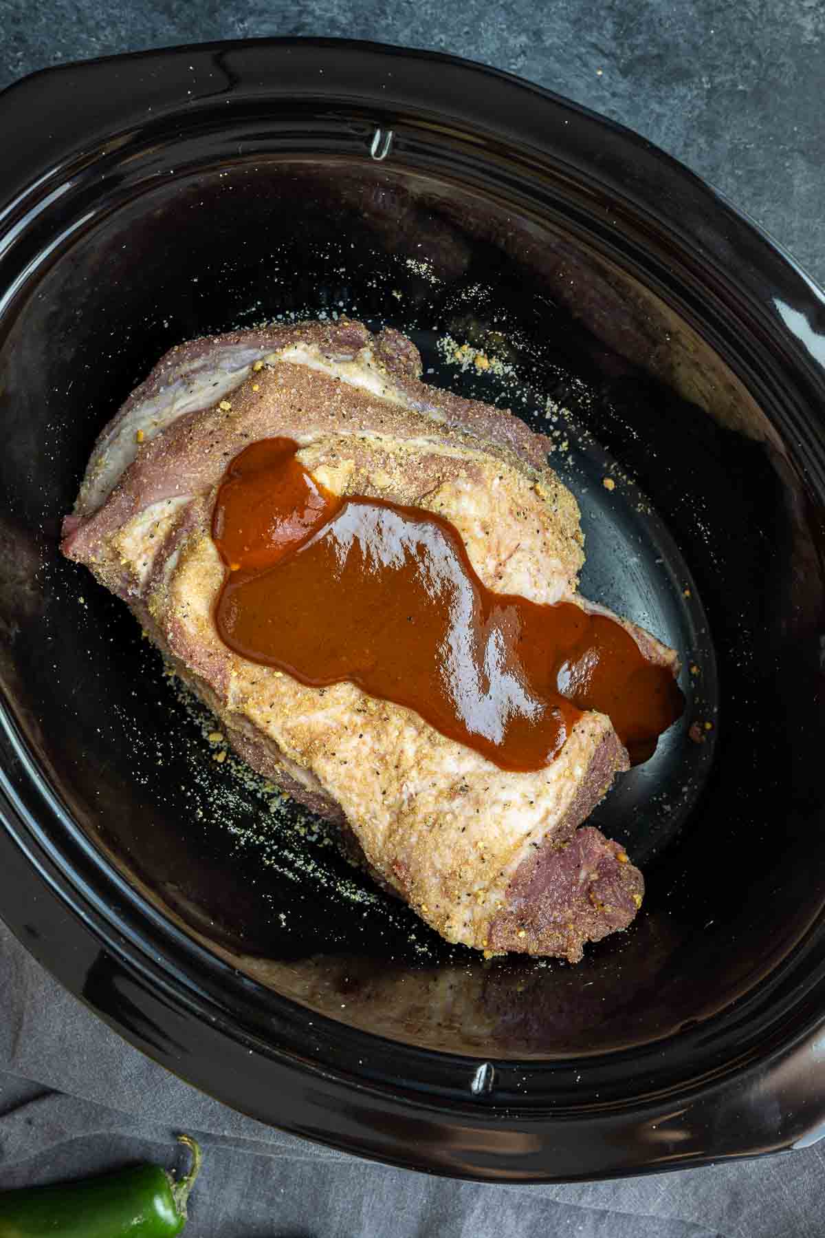 Slow Cooker BBQ Pulled Pork inside slow cooker covered in BBQ sauce