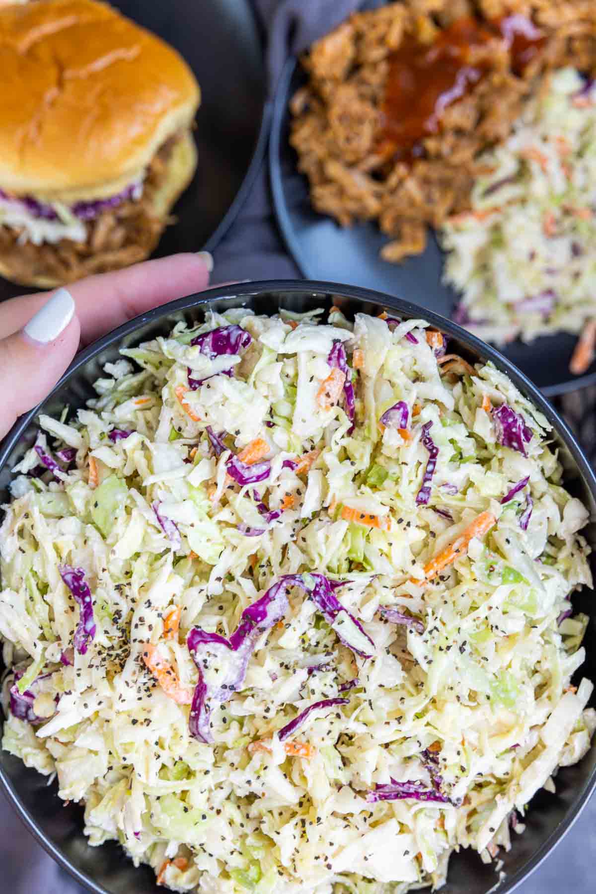 holding a black bowl of Southern Coleslaw