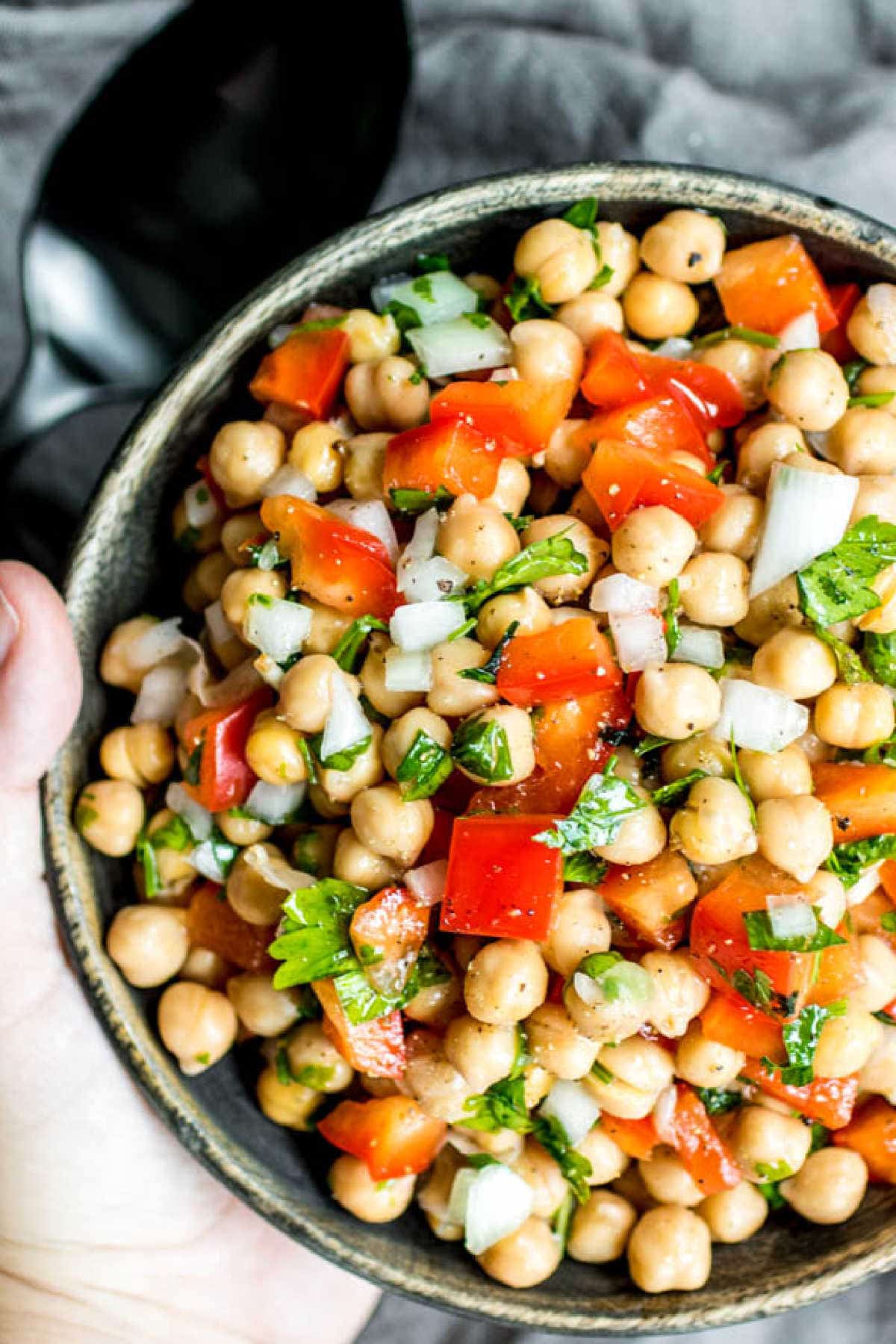 holding a bowl of Mediterranean Chickpea Salad
