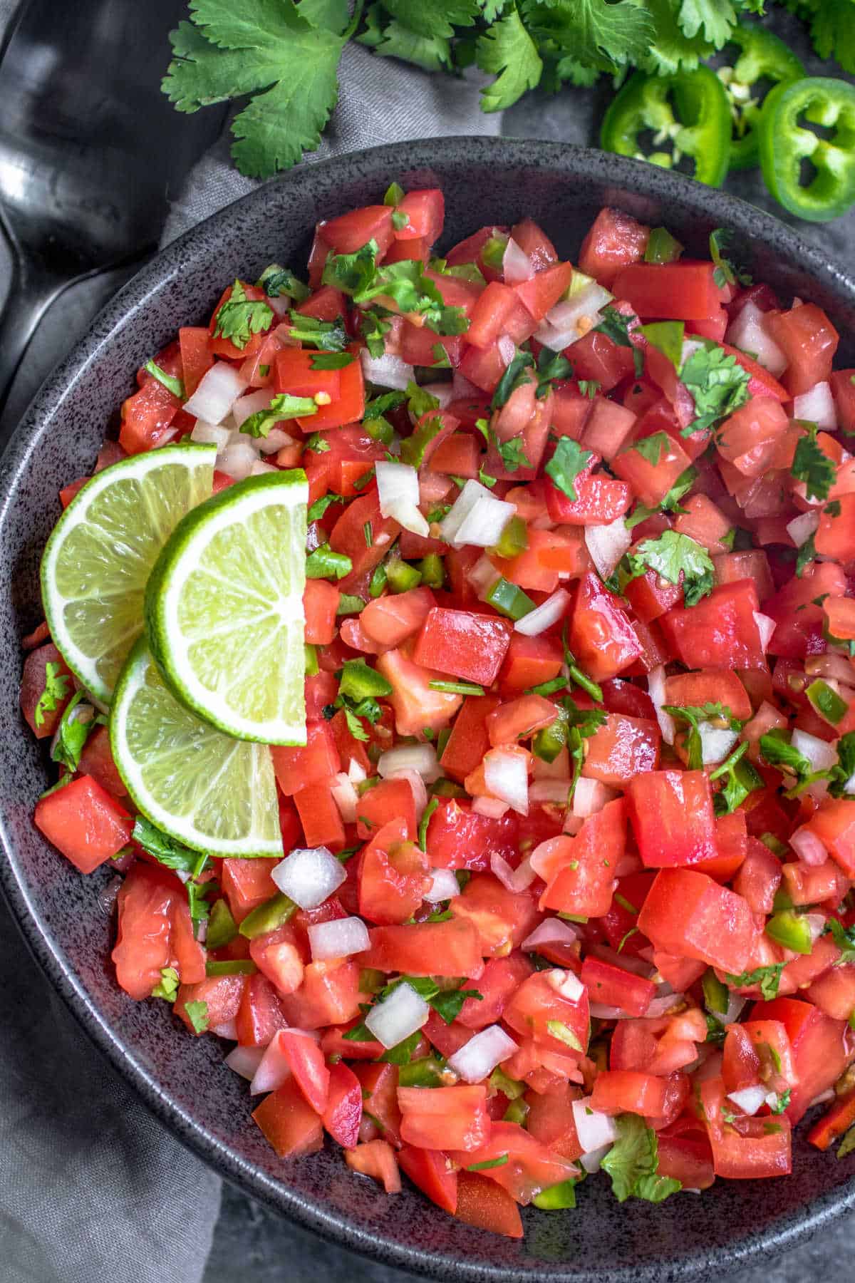 Salsa Fresca in a bowl with fresh parsley and black spoon