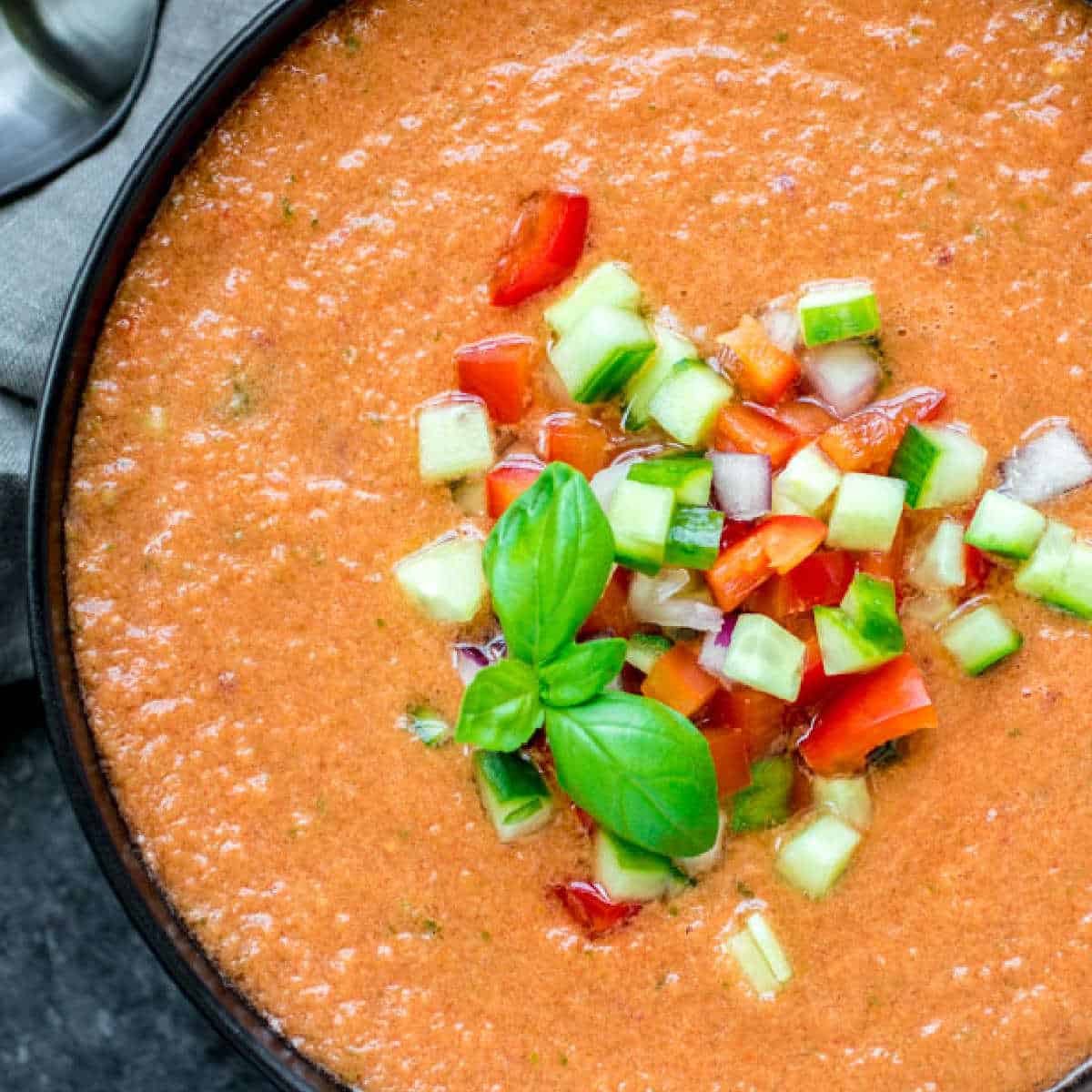 bowl of Gazpacho Soup topped with chopped vegetables