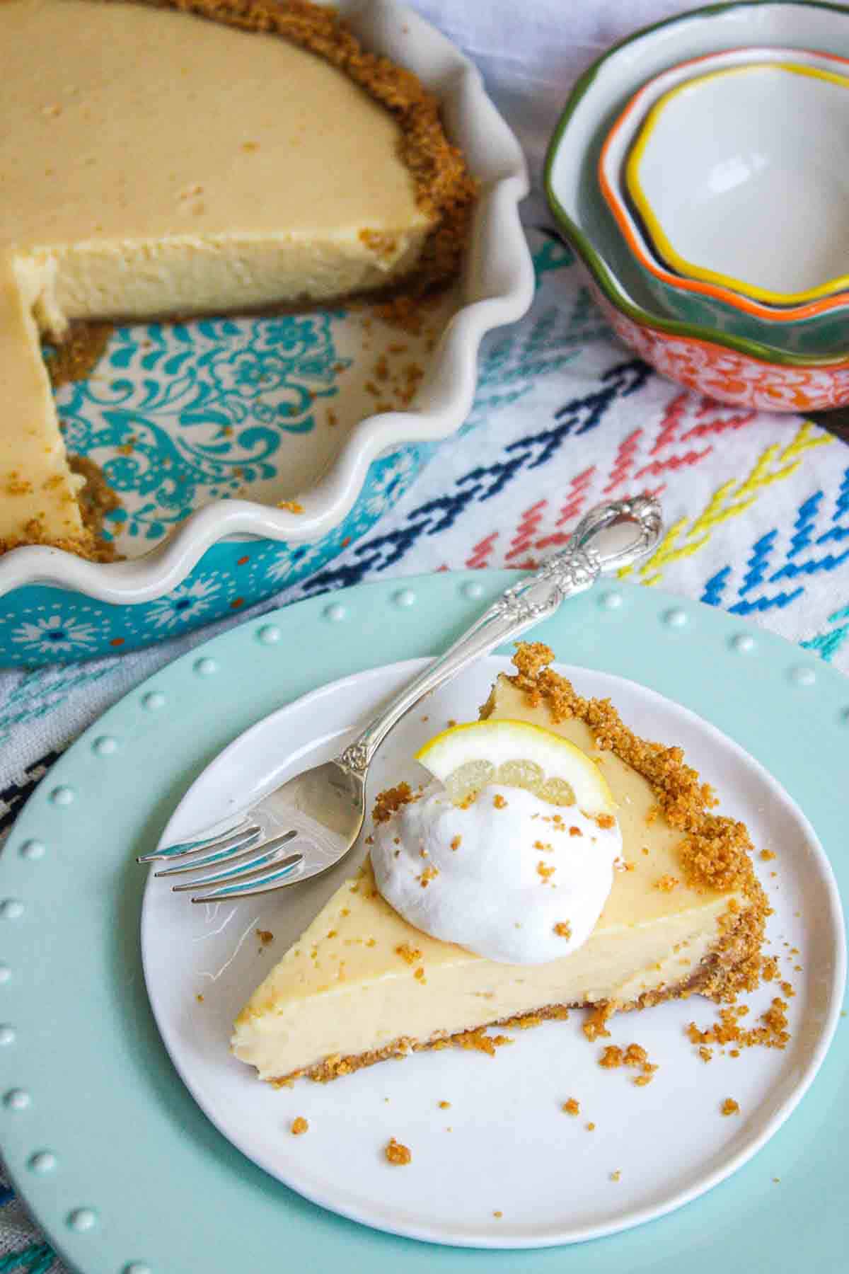 Lemon Icebox Pie in a pie dish with a slice on a plate