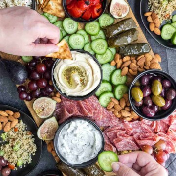 dipping in hummus and dips in Mediterranean Mezze Platter