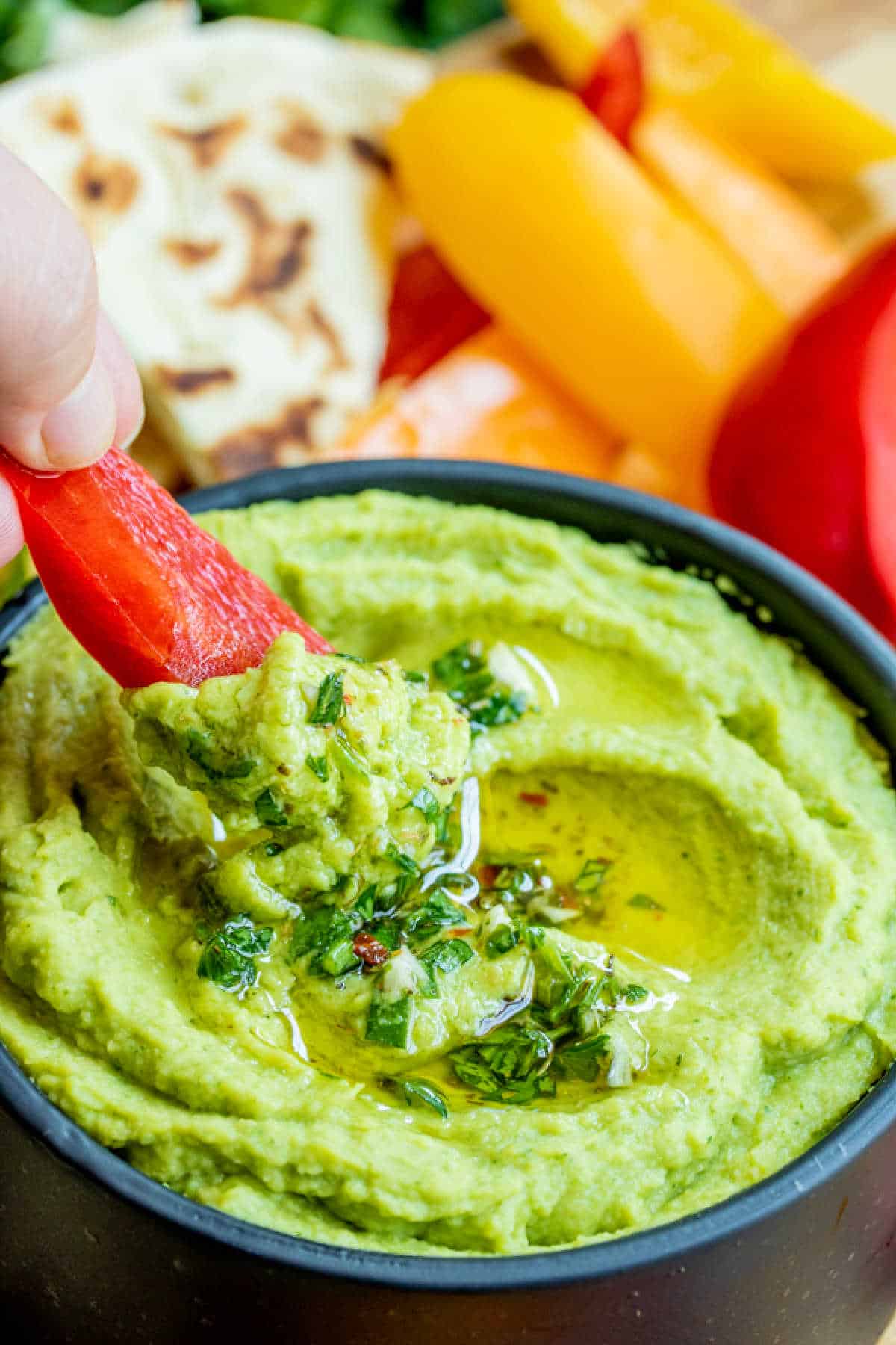 red bell pepper dipped in Avocado Hummus