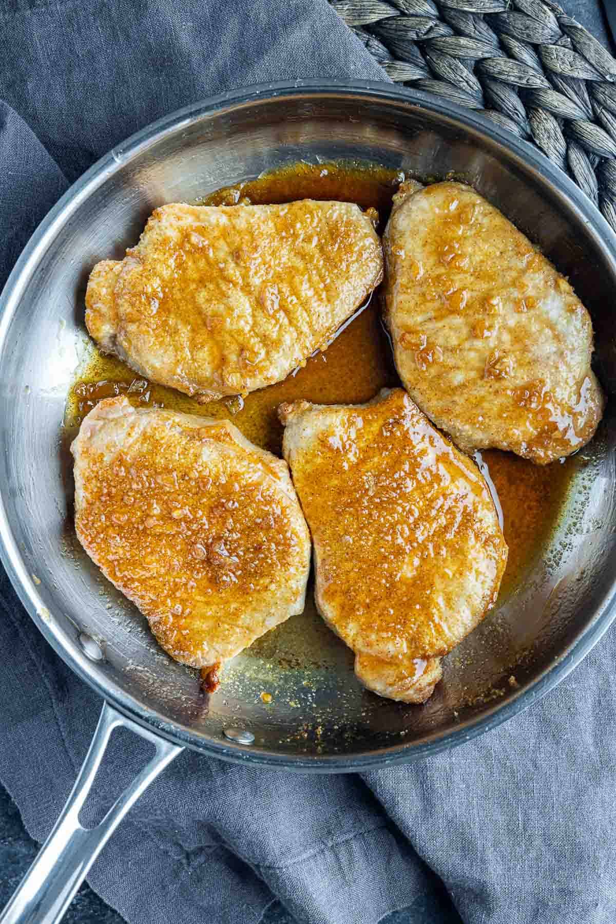 Air Fryer Honey Garlic Pork Chops in a skillet with Asian glaze