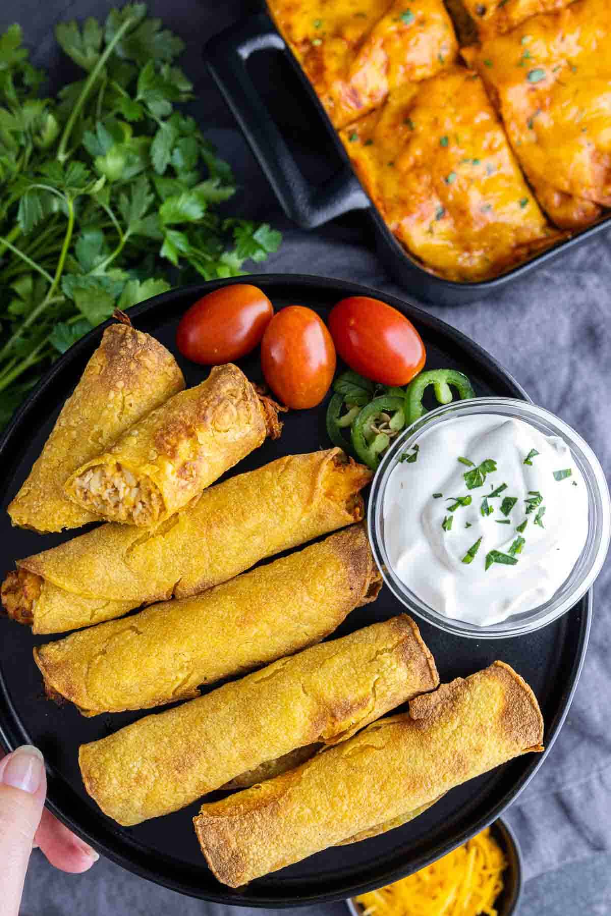 holding a plate of Air Fryer Taquitos