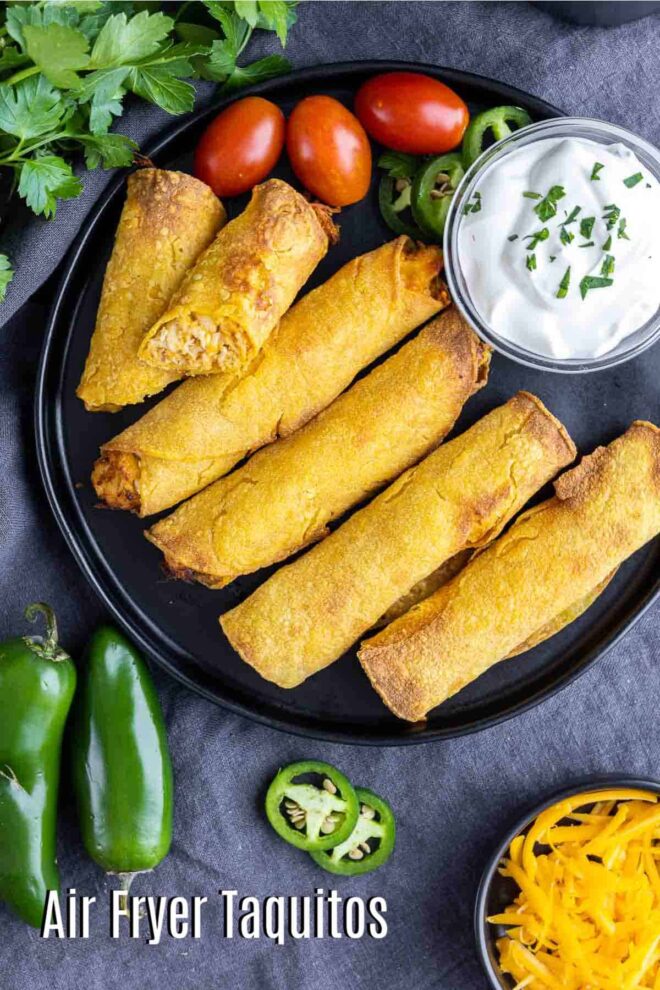 pinterest image of Air Fryer Taquitos on a plate with sour cream, tomatoes, jalapenos, cheese and parsley