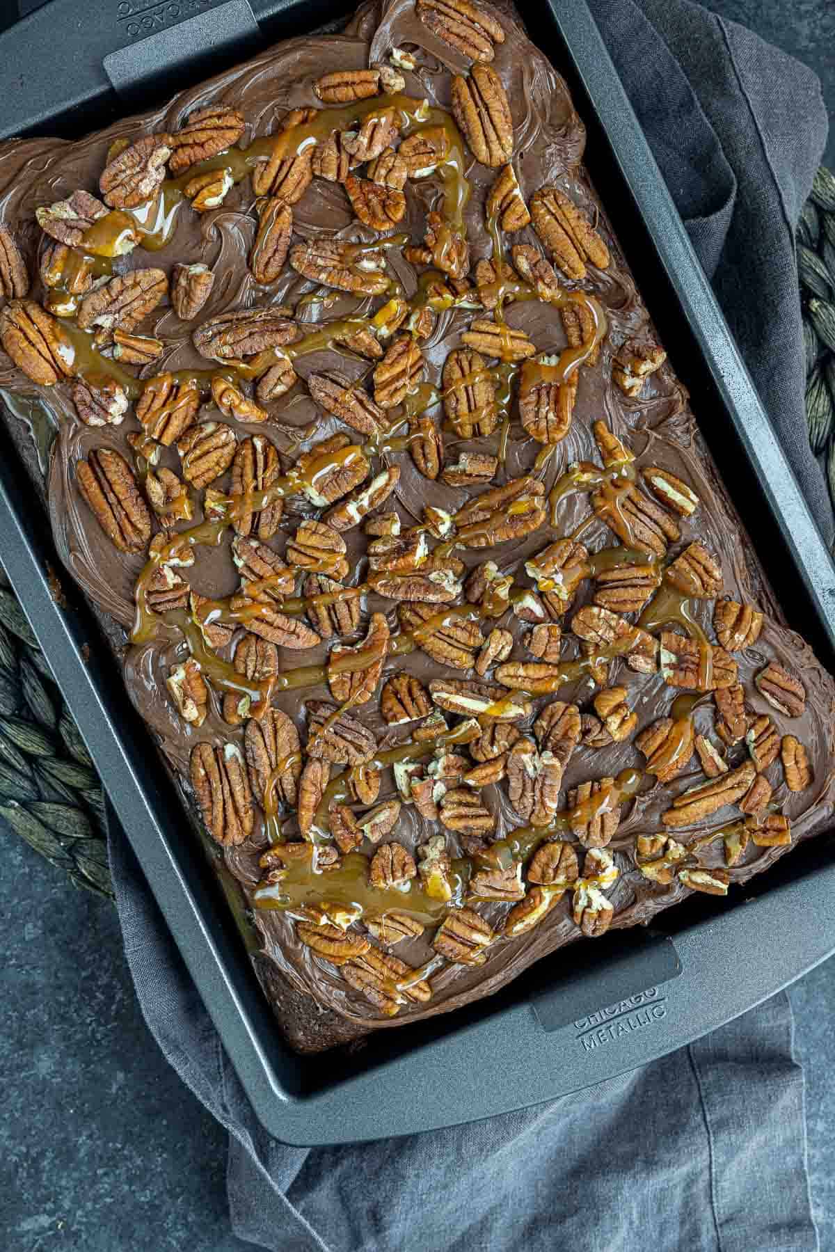 Chocolate Turtle Cake topped with pecans and caramel drizzle