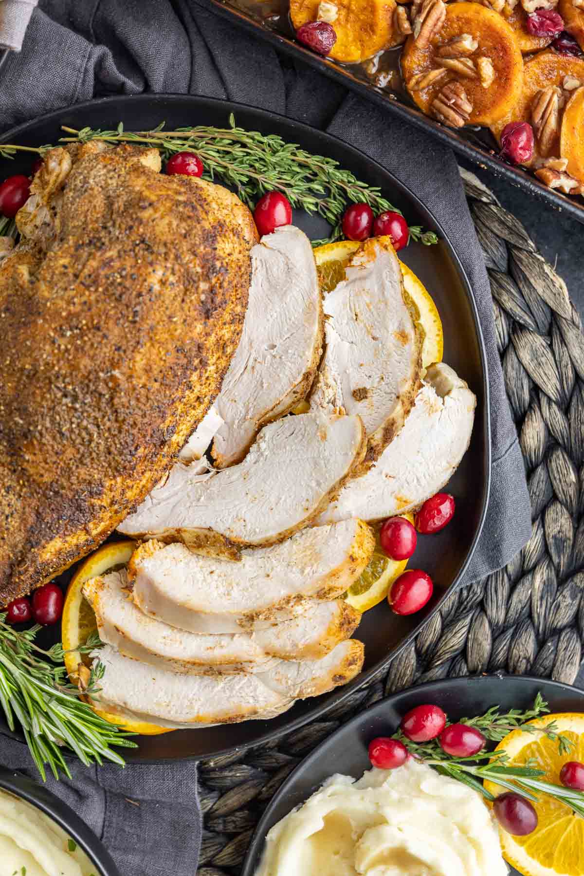 Thanksgiving turkey breast on a black platter with sides