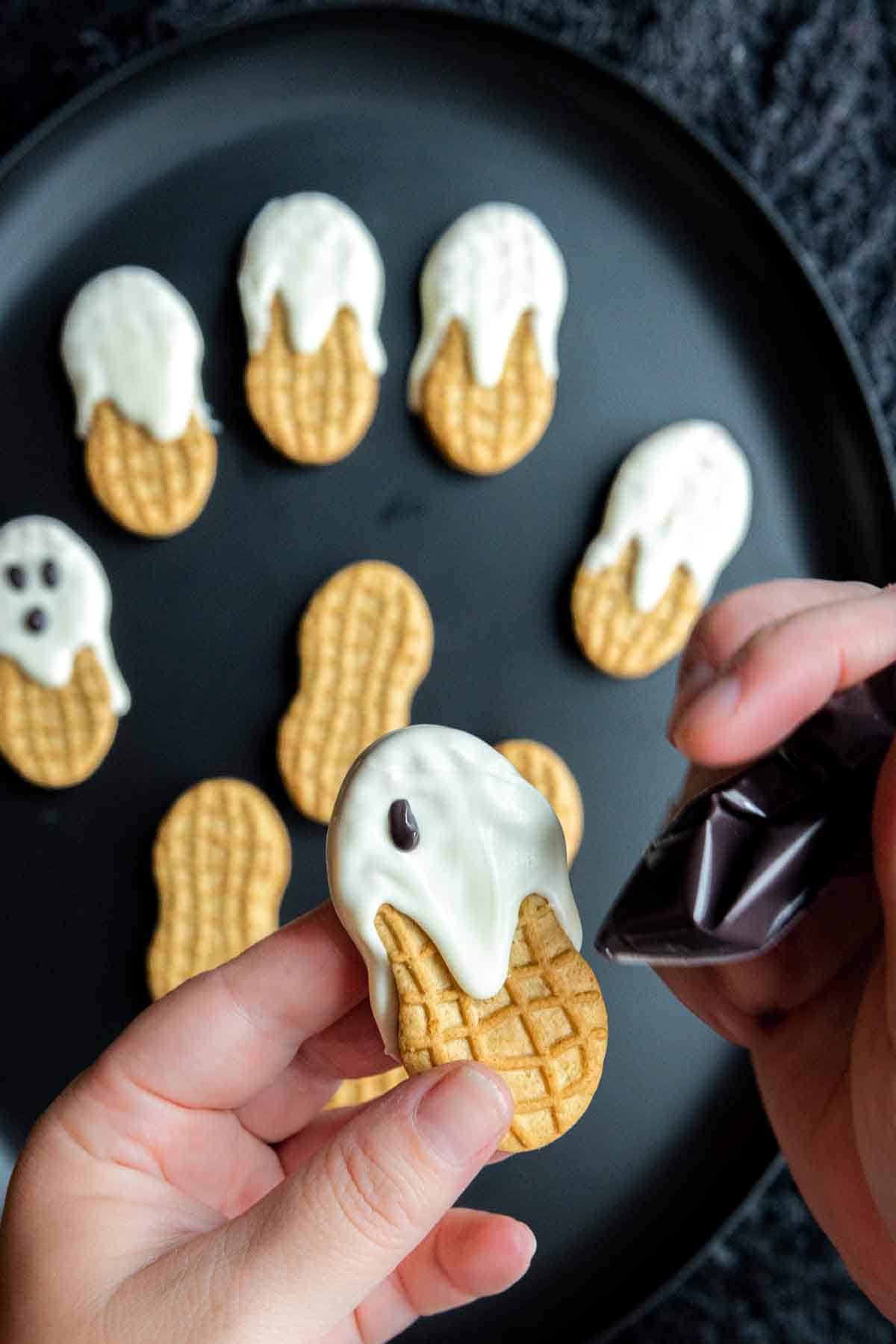 making the eyes on Nutter Butter Ghost Cookies
