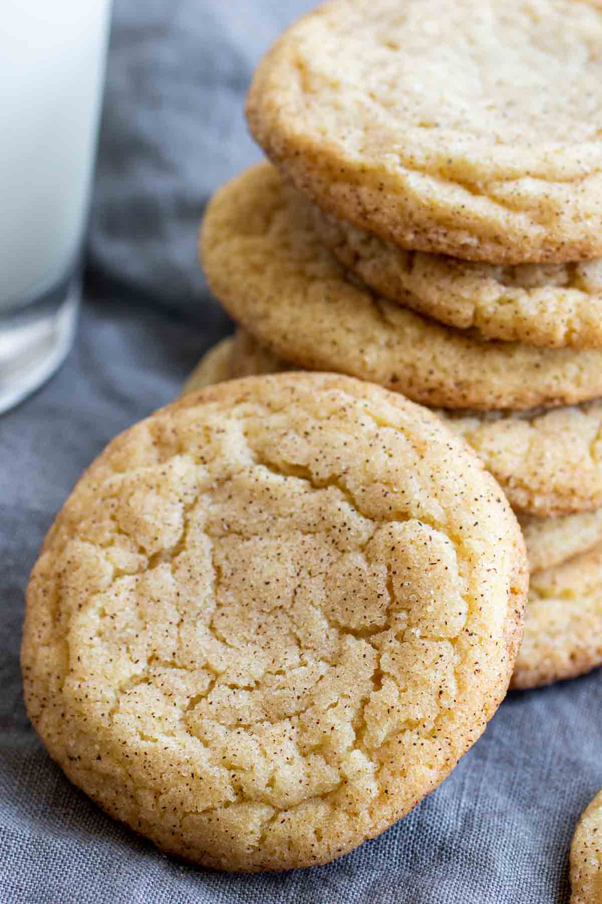 Snickerdoodles stacked with glass of milk in background