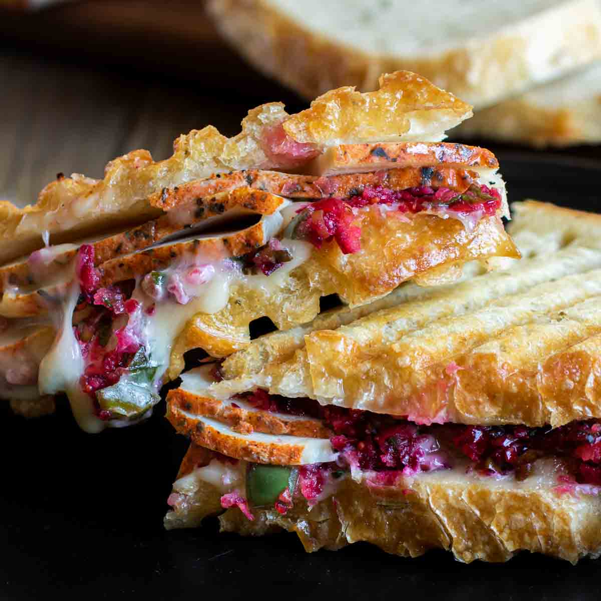 Turkey and Cranberry Panini on a plate cut in half