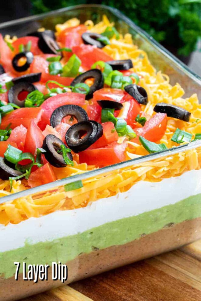 pinterest image of 7 Layer Dip on wooden cutting board