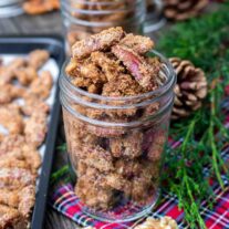 candied nuts in a mason jar with pine branch and plaid napkin