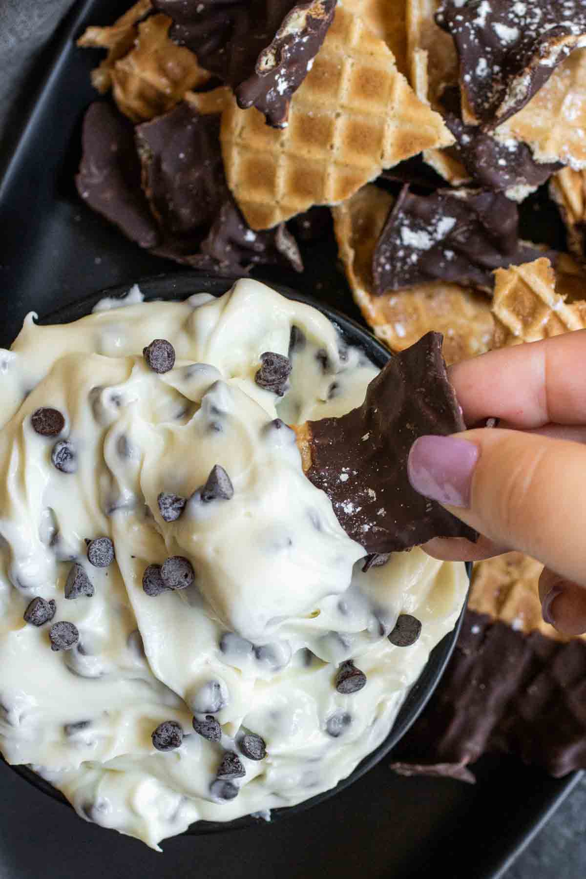 dipping into Cannoli Dip with waffle chip