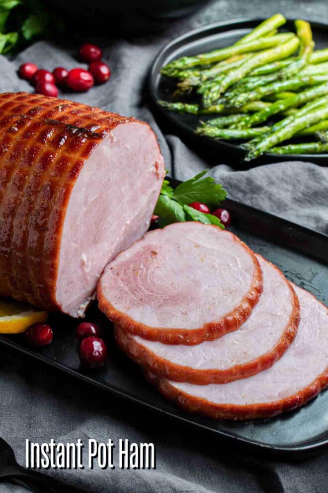 pinterest image of sliced Instant pot ham with asparagus in the background