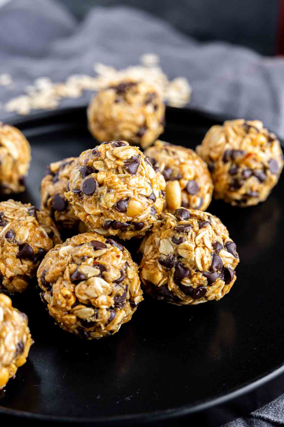 a black plate of stacked Peanut Butter Energy Balls