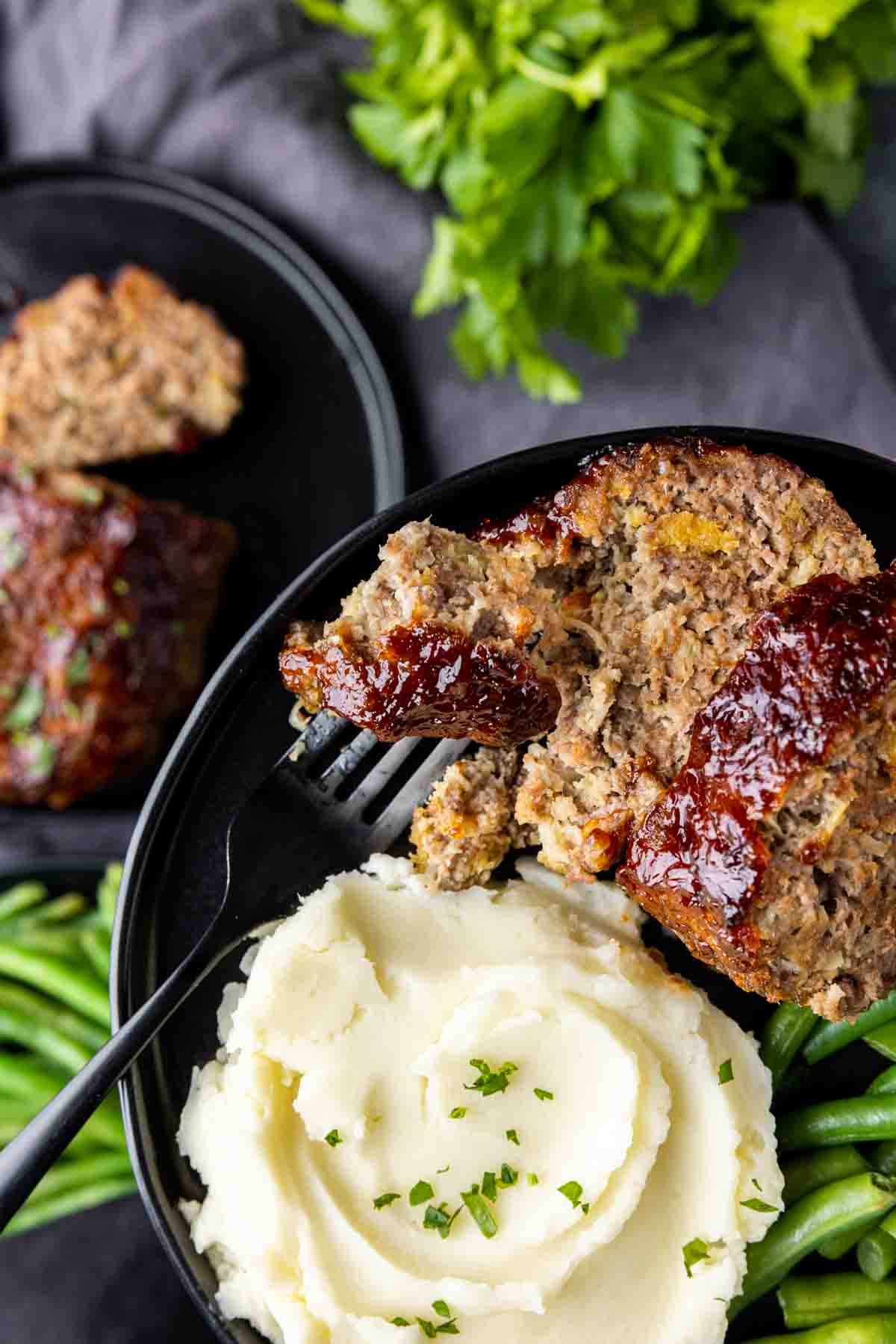 holding a plate with Air Fryer Meatloaf and mashed potatoes